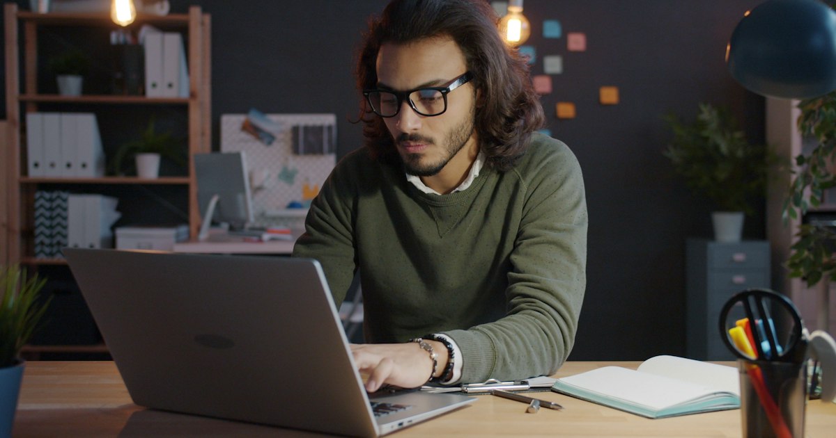 Hombre trabajando solo con un portátil en su escritorio