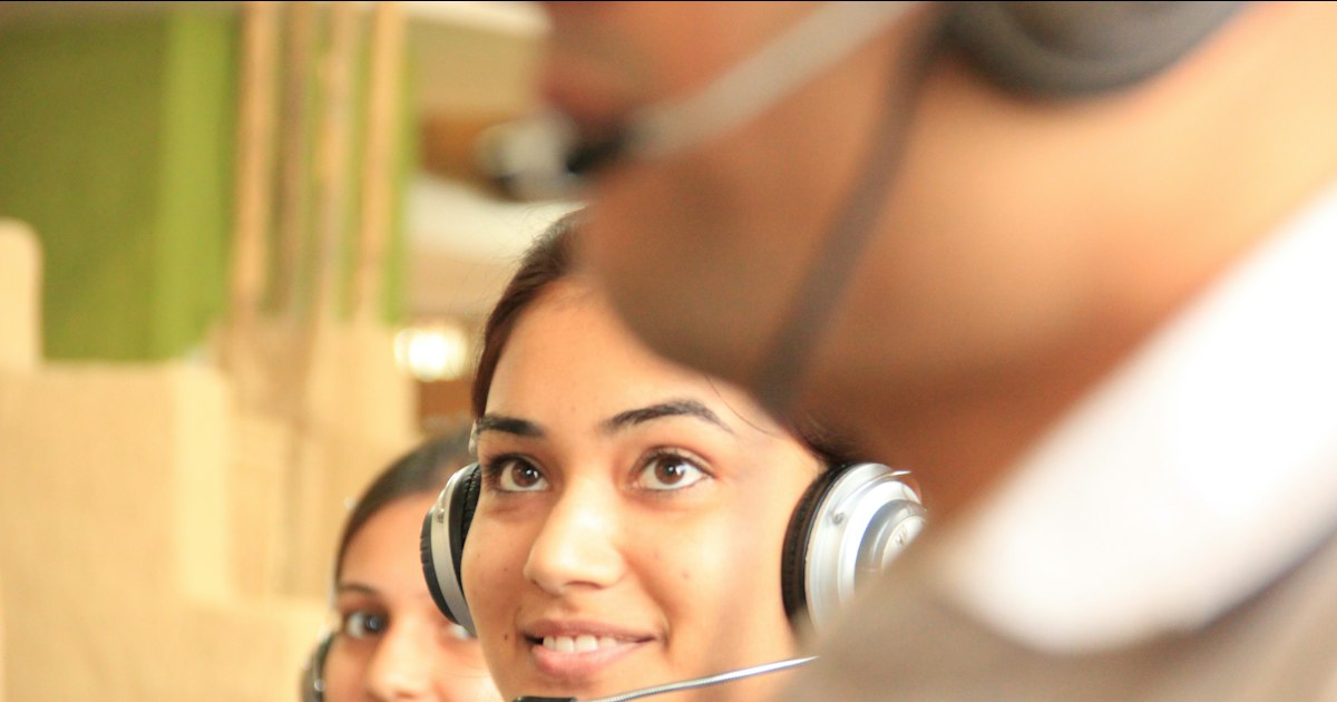 Agente de atención al cliente sonriendo con unos auriculares puestos