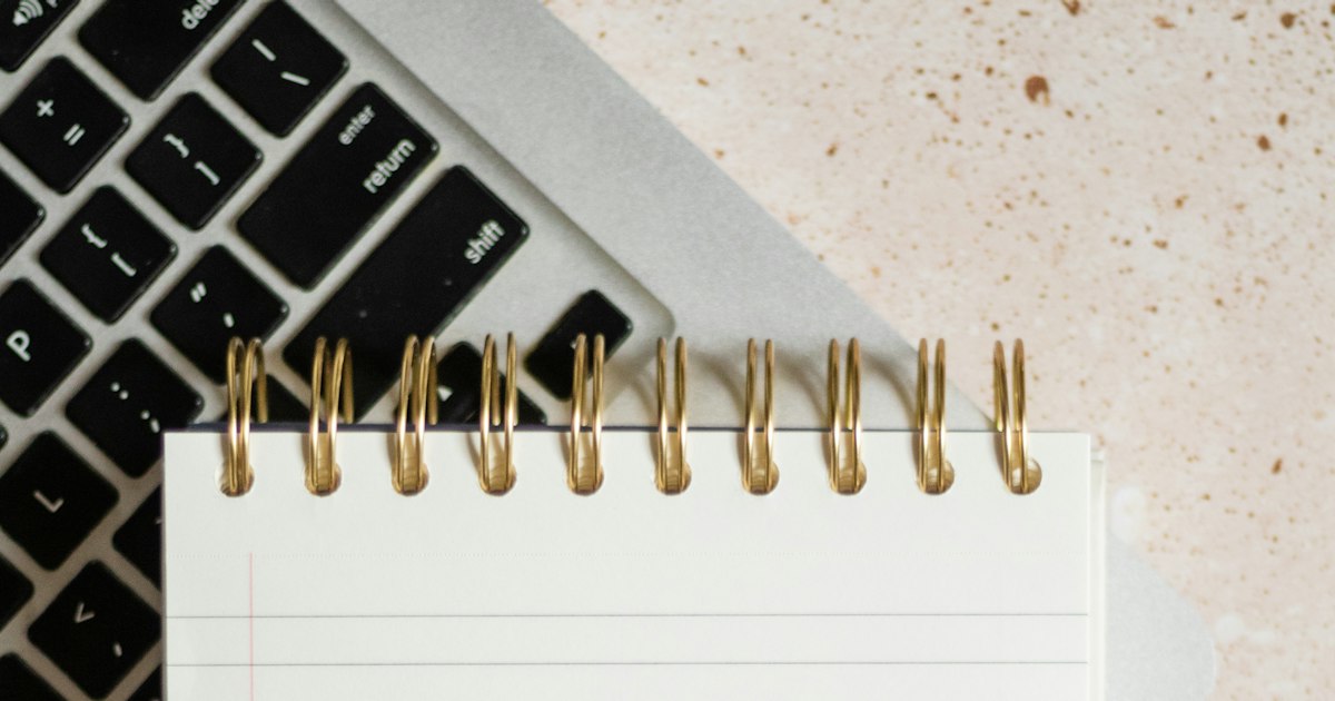 Libreta de espiral sobre el teclado de un portátil