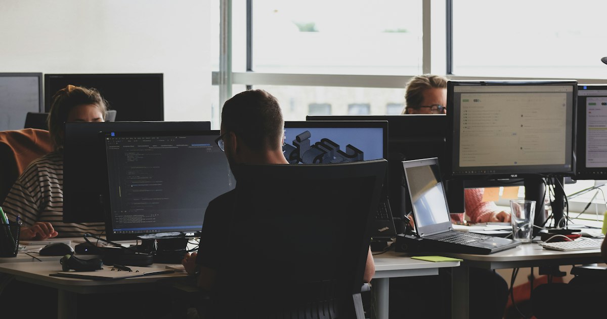 Equipo técnico trabajando con varios monitores en una oficina