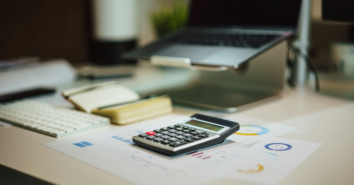 Calculadora y documentos sobre un escritorio de oficina