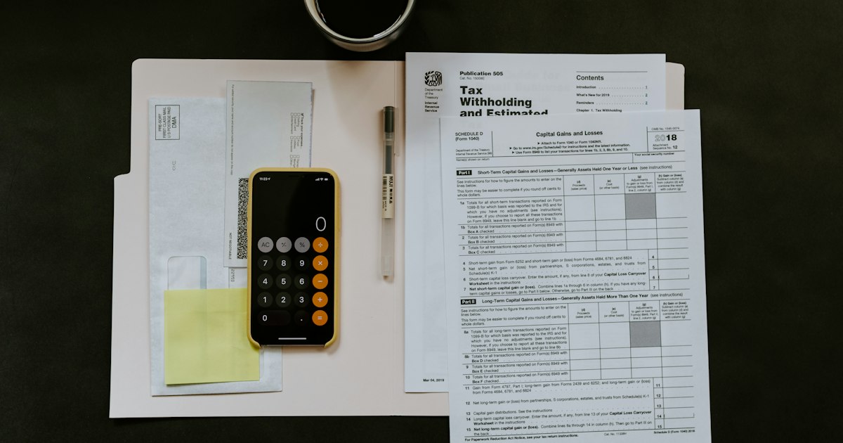 Documentos, formularios y un móvil sobre una mesa