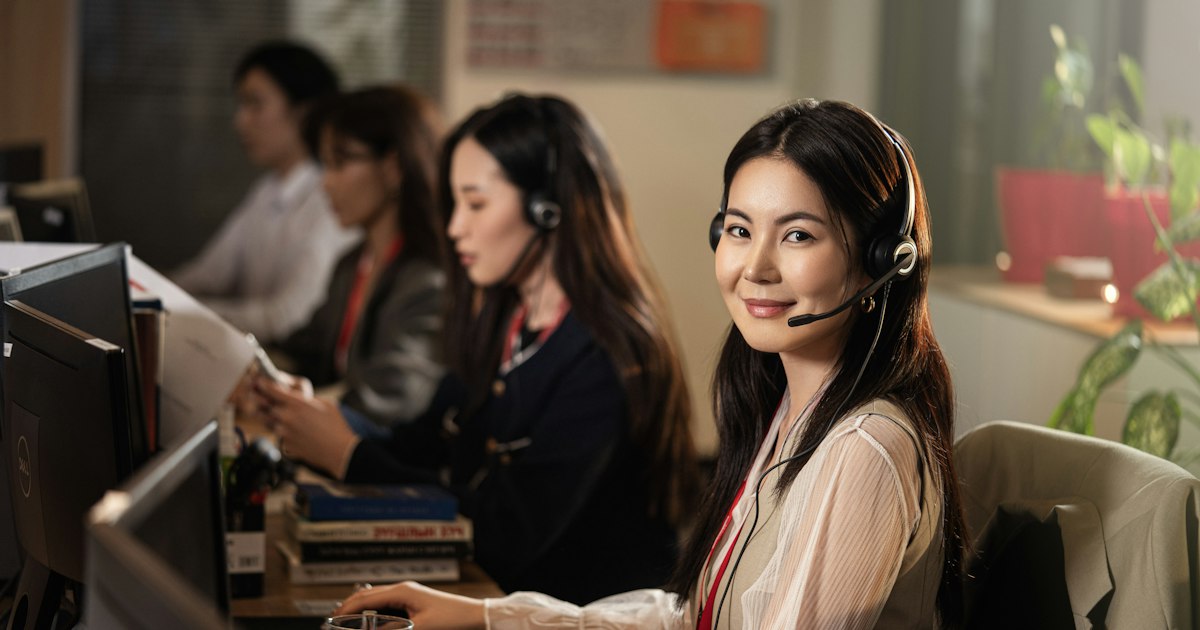 Equipo de atención al cliente trabajando con auriculares en una oficina