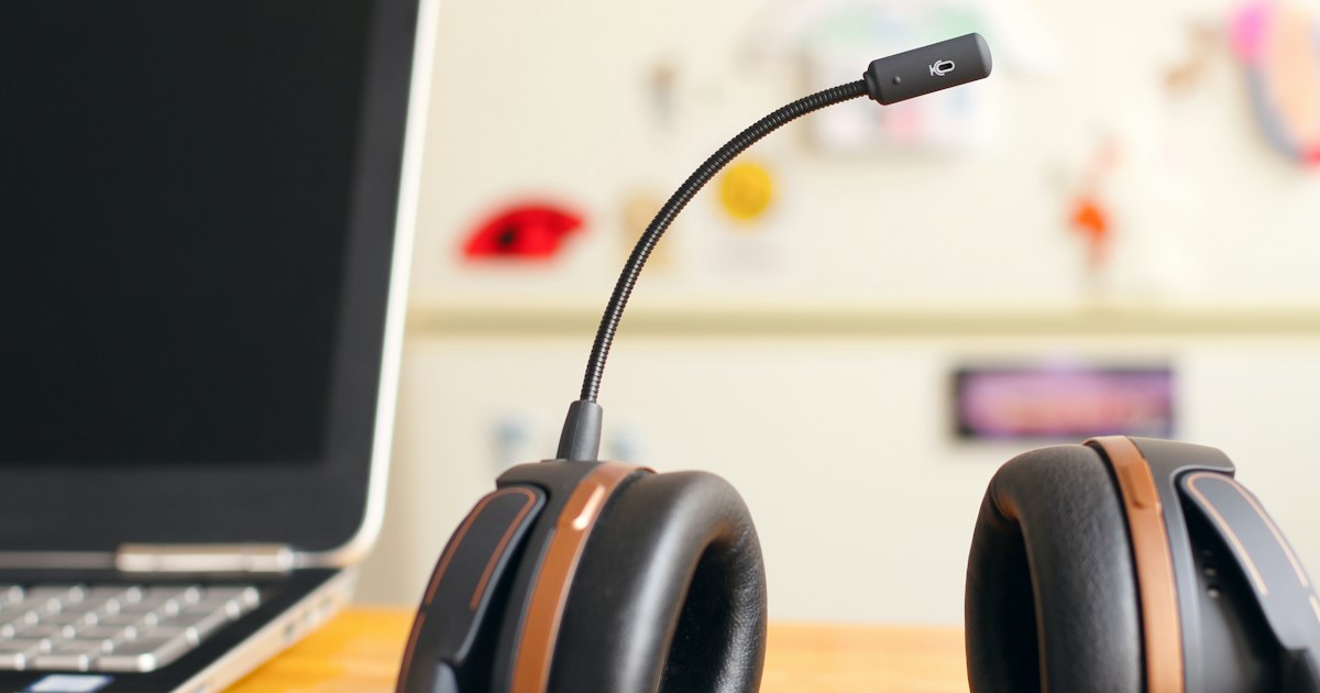Auriculares con micrófono junto a un portátil