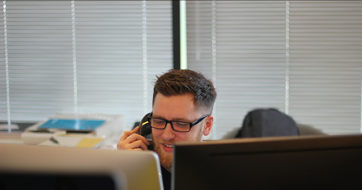 Hombre hablando por teléfono en su puesto de trabajo