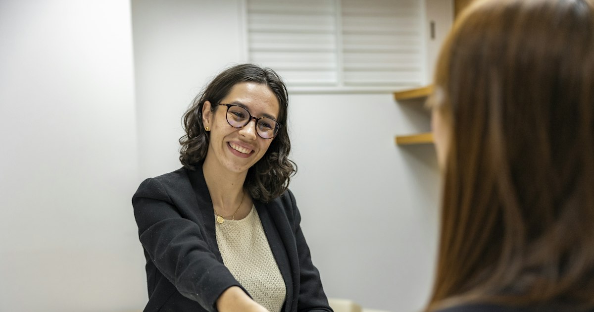 Mujer sonriendo en una entrevista de trabajo