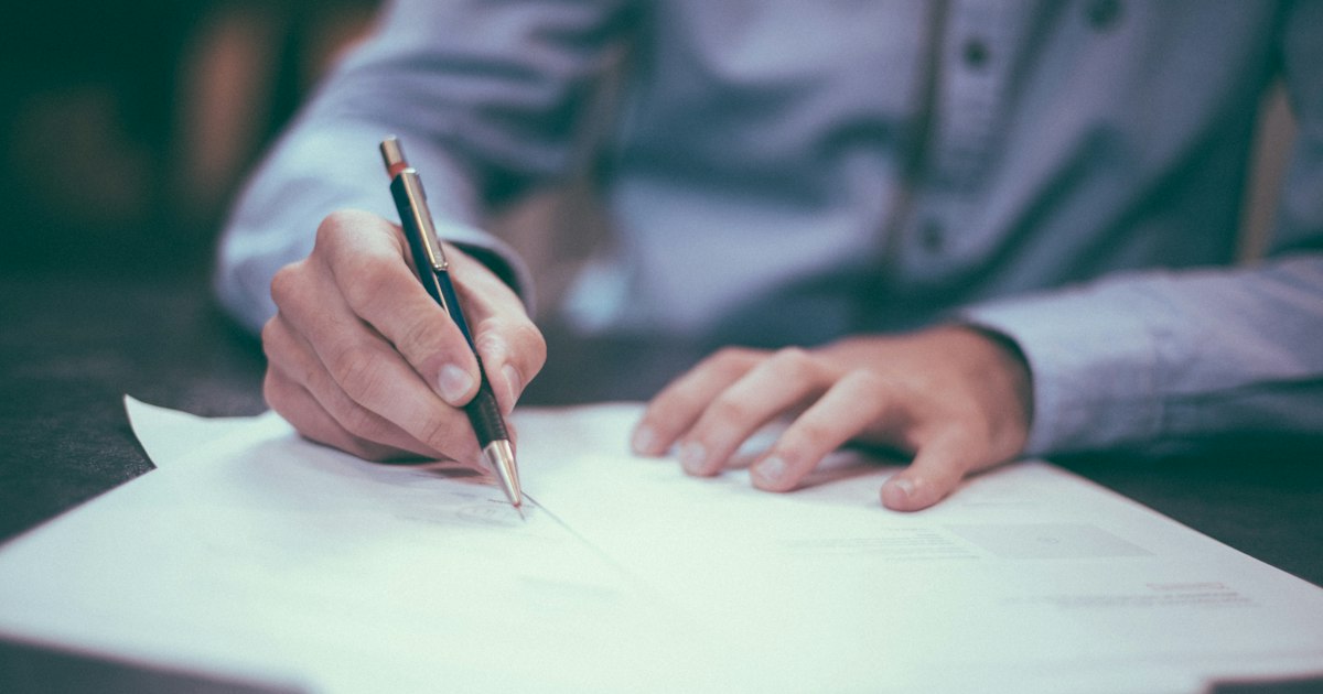 Mano firmando un contrato con un bolígrafo