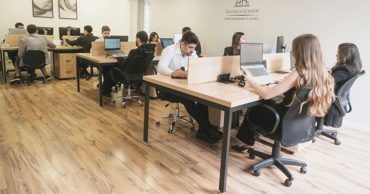 Oficina con un equipo trabajando en mesas compartidas