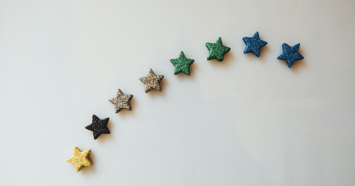 Estrellas de colores colocadas en arco sobre fondo blanco